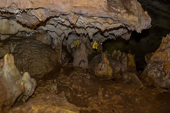 From Tirana: Hiking to Pellumbas cave and Petrela Castle - Inside Pellumbas Cave with a torch and helmet